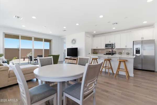 a view of a dining room with furniture a kitchen and chandelier