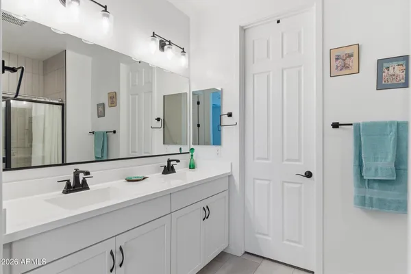 a bathroom with double vanity sink and mirror