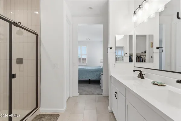 a en suite bathroom with a shower sink and mirror