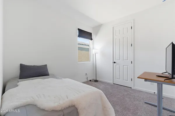 a bedroom with a bed and a flat tv screen on a dresser