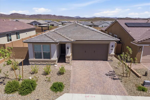 a front view of a house with a yard and mountain view in back