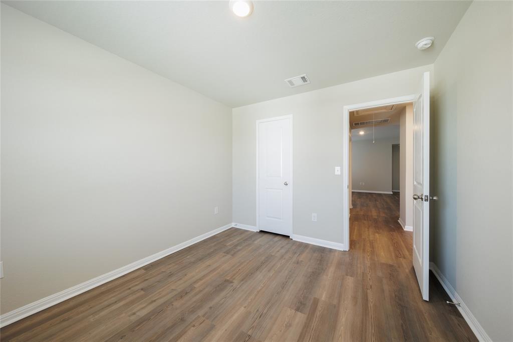 521 Otto Avenue Georgetown, TX 78626 - Photo 18 of 38 Unfurnished bedroom featuring baseboards and dark wood-style floors