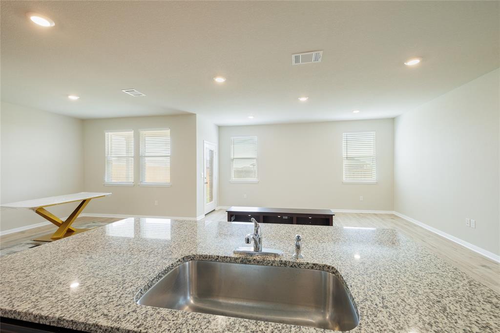 521 Otto Avenue Georgetown, TX 78626 - Photo 35 of 38 Kitchen featuring light wood-style flooring, light stone countertops, open floor plan, and recessed lighting