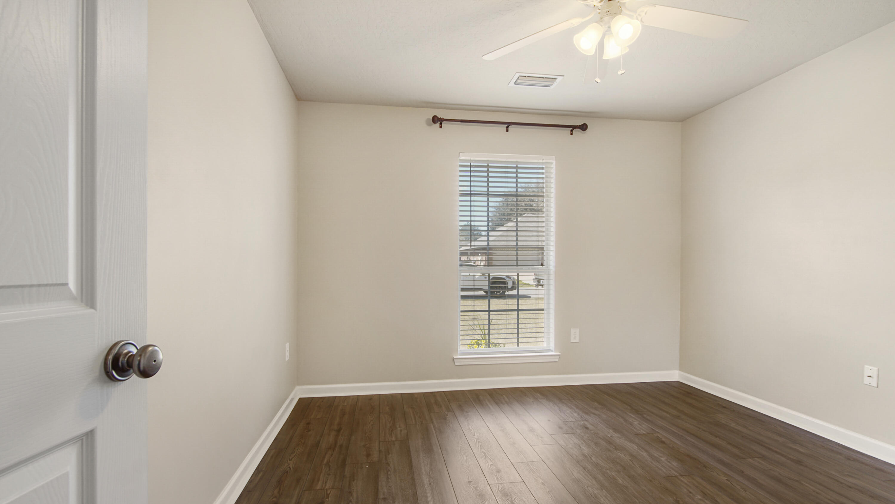 5227 Moore Loop Crestview, FL 32536 - Photo 27 of 43 an empty room with wooden floor cabinet and windows