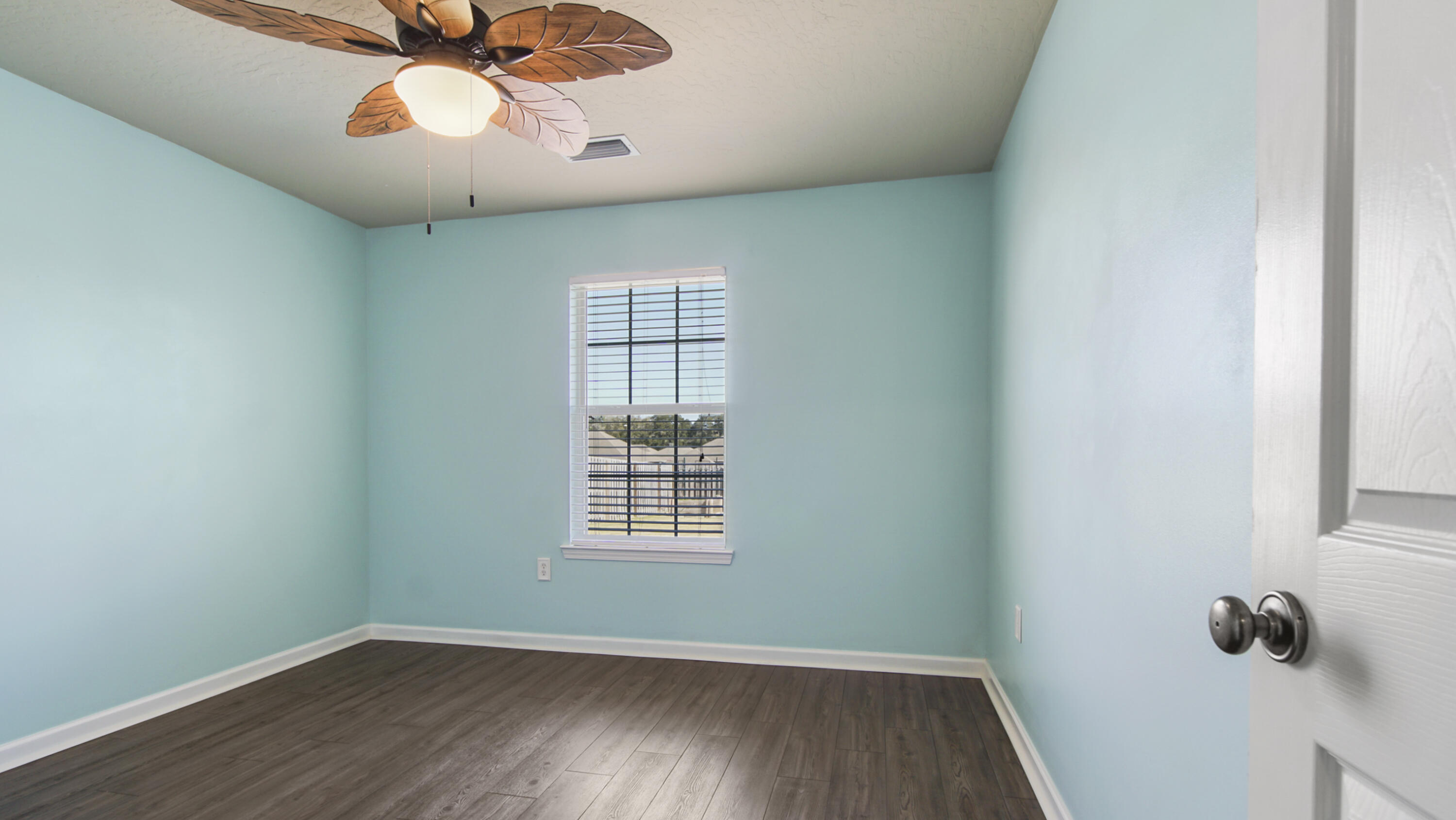 5227 Moore Loop Crestview, FL 32536 - Photo 30 of 43 an empty room with wooden floor fan and windows