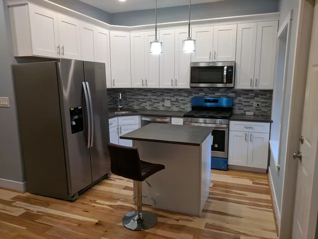 a kitchen with stainless steel appliances granite countertop a refrigerator and a stove