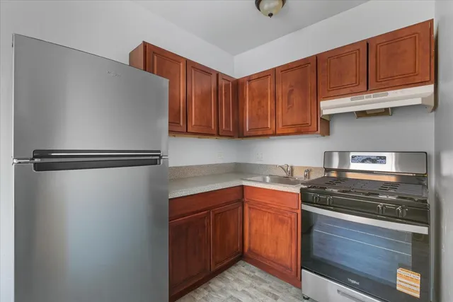 a kitchen with stainless steel appliances granite countertop a stove a sink and a refrigerator