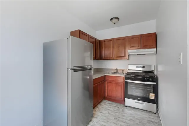 a kitchen with stainless steel appliances granite countertop a refrigerator and a stove