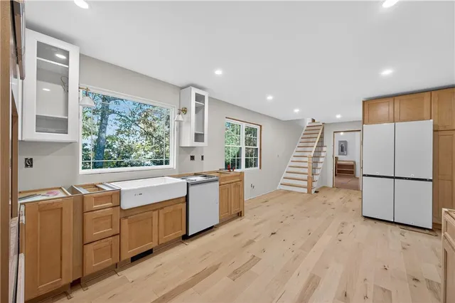 a large white kitchen with a stove a sink dishwasher and a refrigerator
