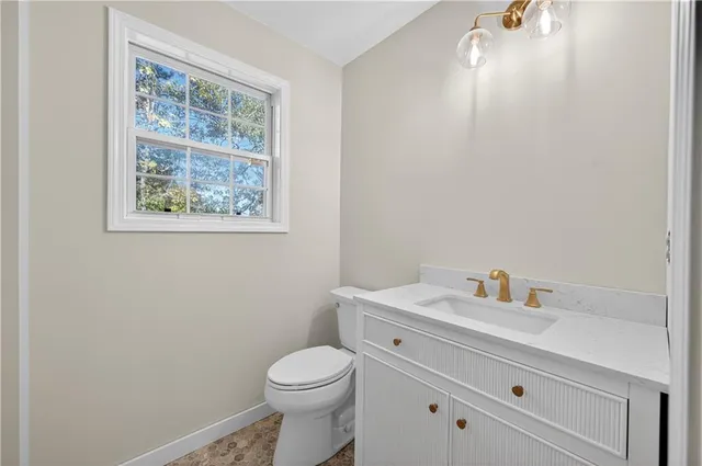 a bathroom with a toilet a sink and a window