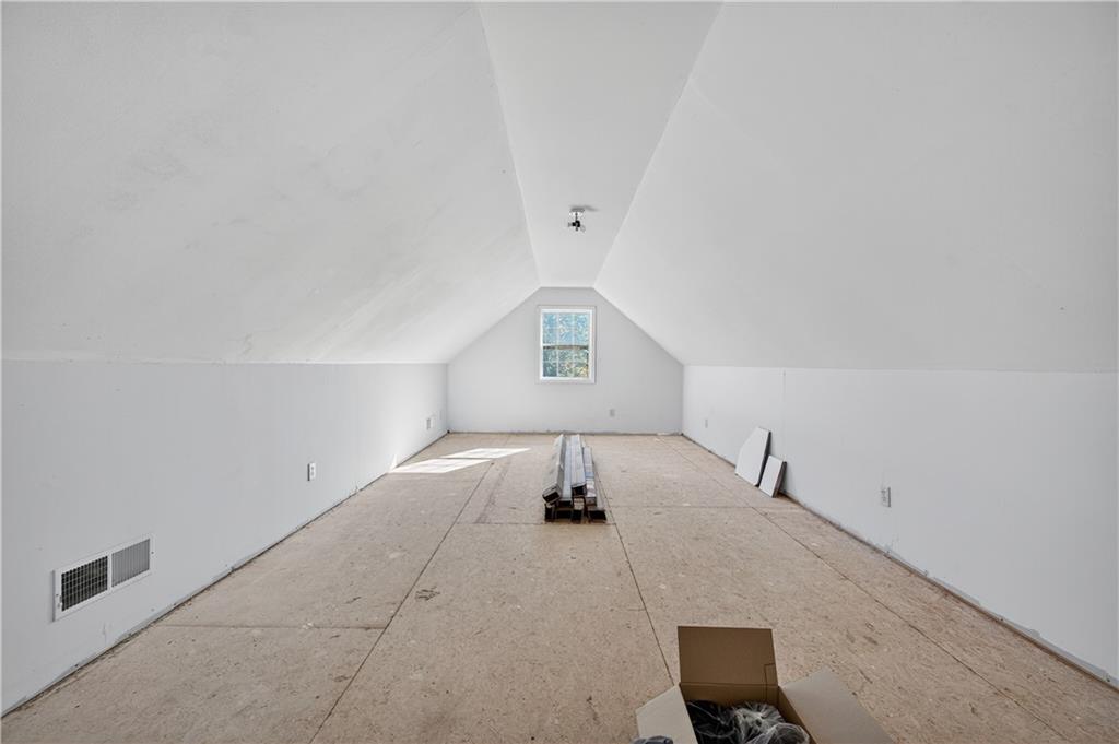 4460 Suwanee Dam Road Suwanee, GA 30024 - Photo 29 of 38 a bedroom with a bed and a chandelier