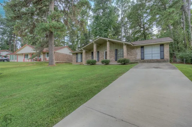 a front view of a house with a garden and trees
