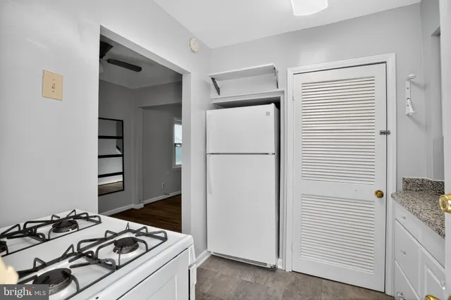 a kitchen with granite countertop a sink a stove and cabinets