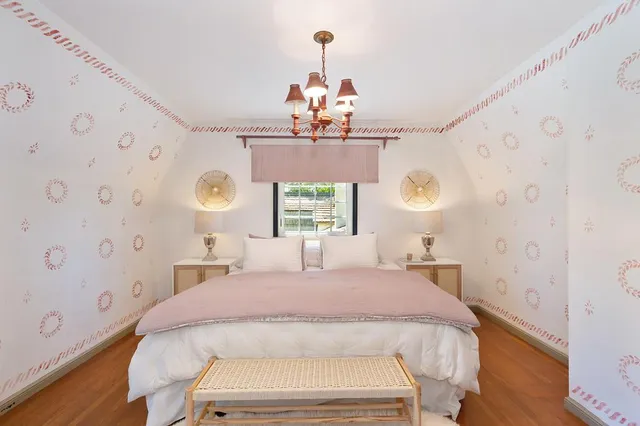 a spacious bedroom with a bed and a chandelier