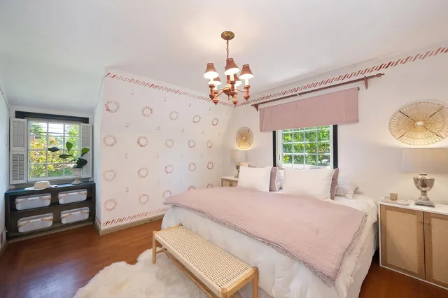 a spacious bedroom with a large bed and a chandelier
