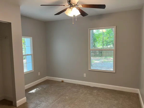 an empty room with a window and a fan