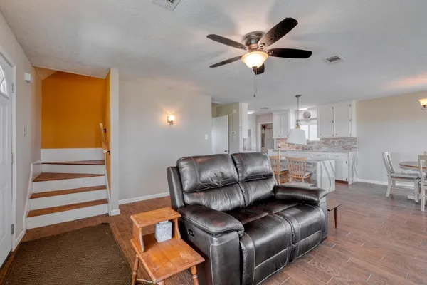 a living room with furniture and a ceiling fan