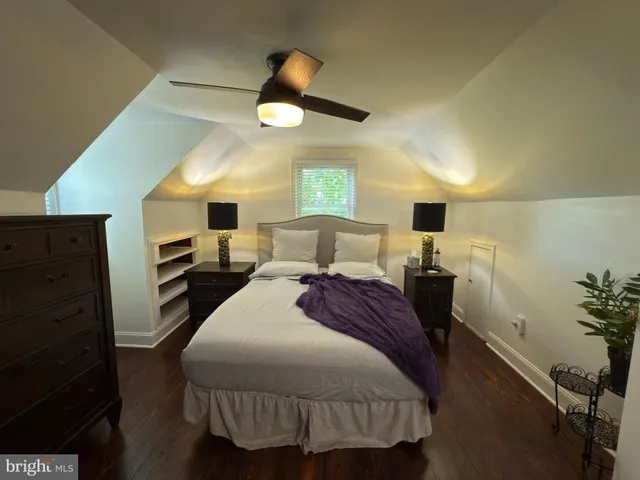 a spacious bedroom with a bed and a dresser next to a window
