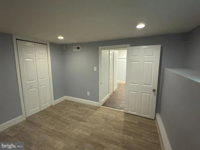 an empty room with closet and wooden floor