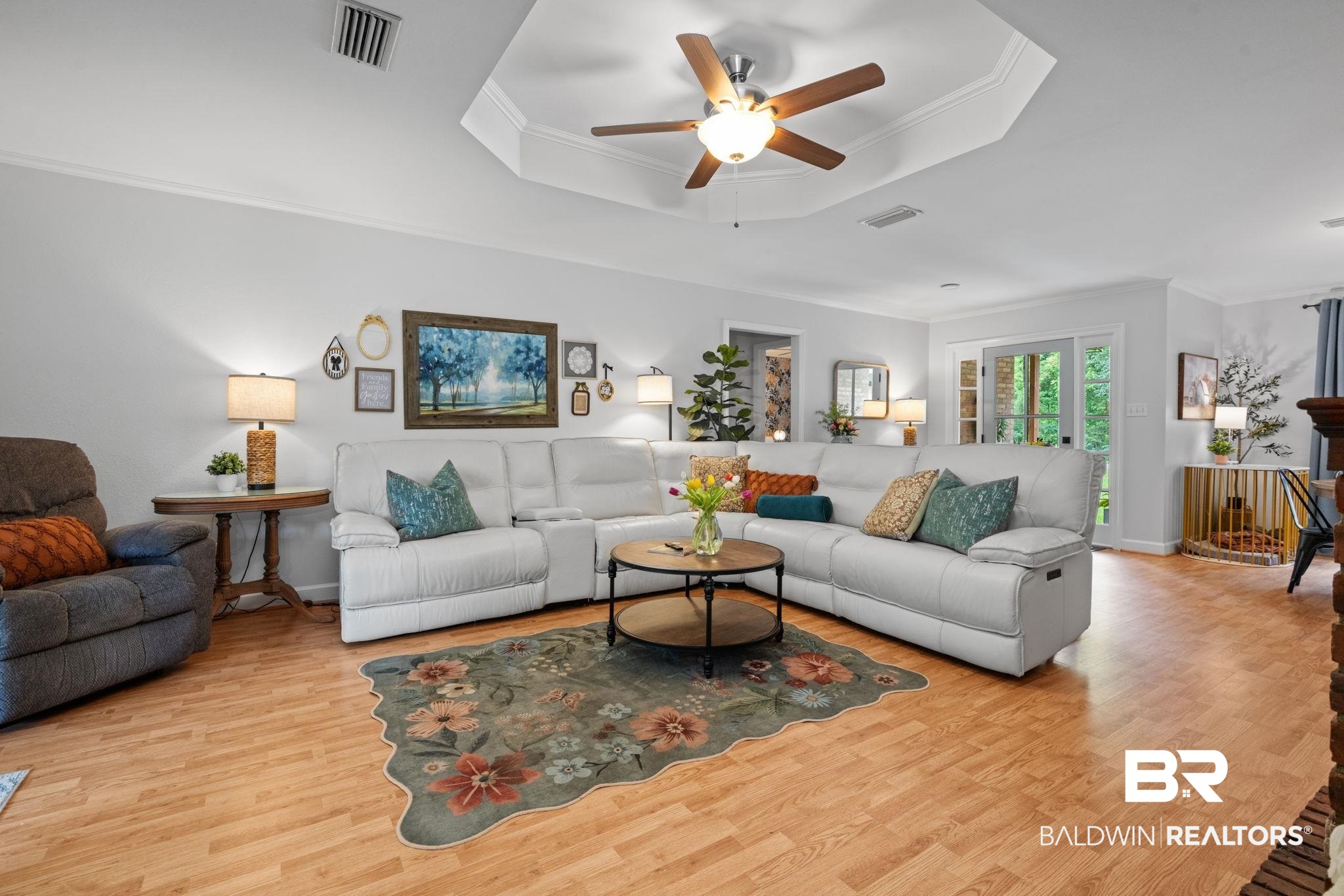5936 Lundy Road Theodore, AL 36582 - Photo 2 of 32 Living area featuring a tray ceiling with a ceiling fan, light-toned wood-finish flooring, and crown molding