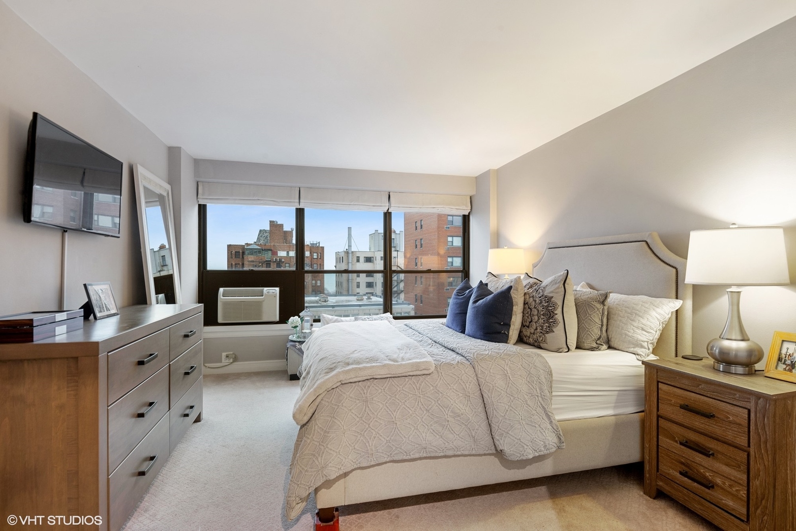 2930 North Sheridan Road, Unit 1611 Chicago, IL 60657 - Photo 11 of 18 a large bedroom with a bed wooden floor and flat screen tv