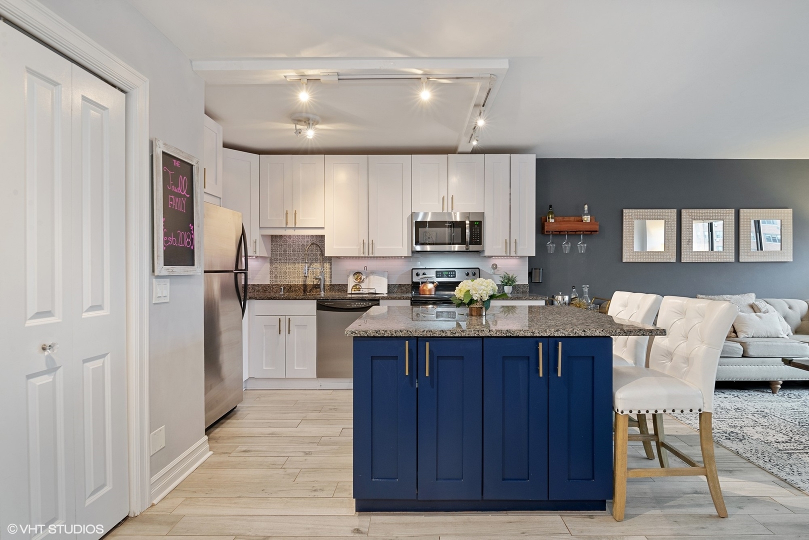2930 North Sheridan Road, Unit 1611 Chicago, IL 60657 - Photo 5 of 18 a kitchen with kitchen island granite countertop wooden cabinets and white appliances