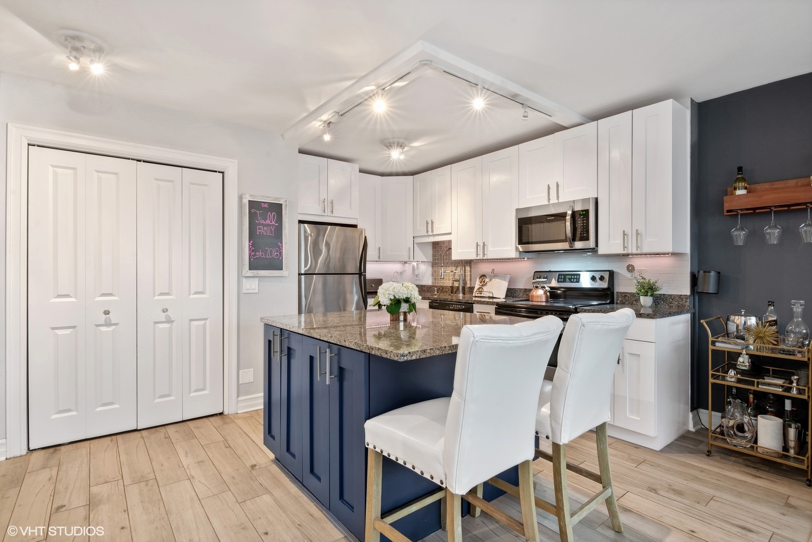2930 North Sheridan Road, Unit 1611 Chicago, IL 60657 - Photo 6 of 18 a kitchen with stainless steel appliances granite countertop a refrigerator a stove top oven a sink dishwasher and white cabinets with wooden floor