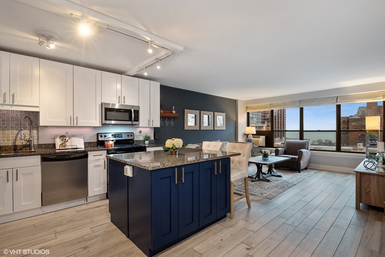 2930 North Sheridan Road, Unit 1611 Chicago, IL 60657 - Photo 7 of 18 a open kitchen with stainless steel appliances granite countertop a lot of counter space and wooden floor