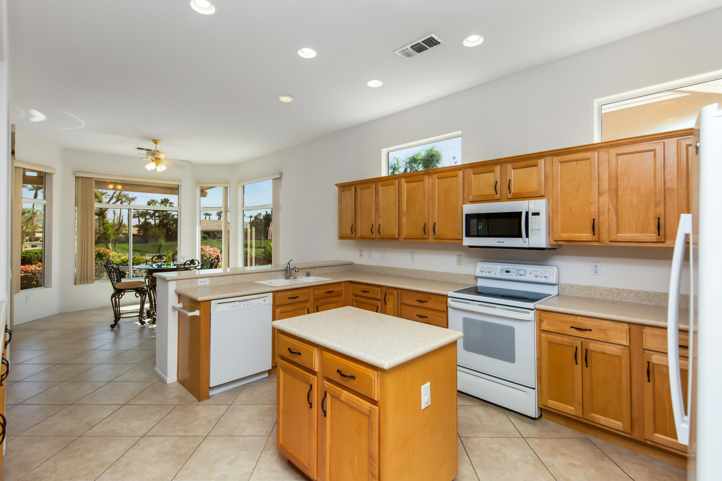 35076 Moorbrook Road Palm Desert, CA 92211 - Photo 17 of 45 a kitchen with stainless steel appliances granite countertop a stove top oven a sink dishwasher and white cabinets with wooden floor