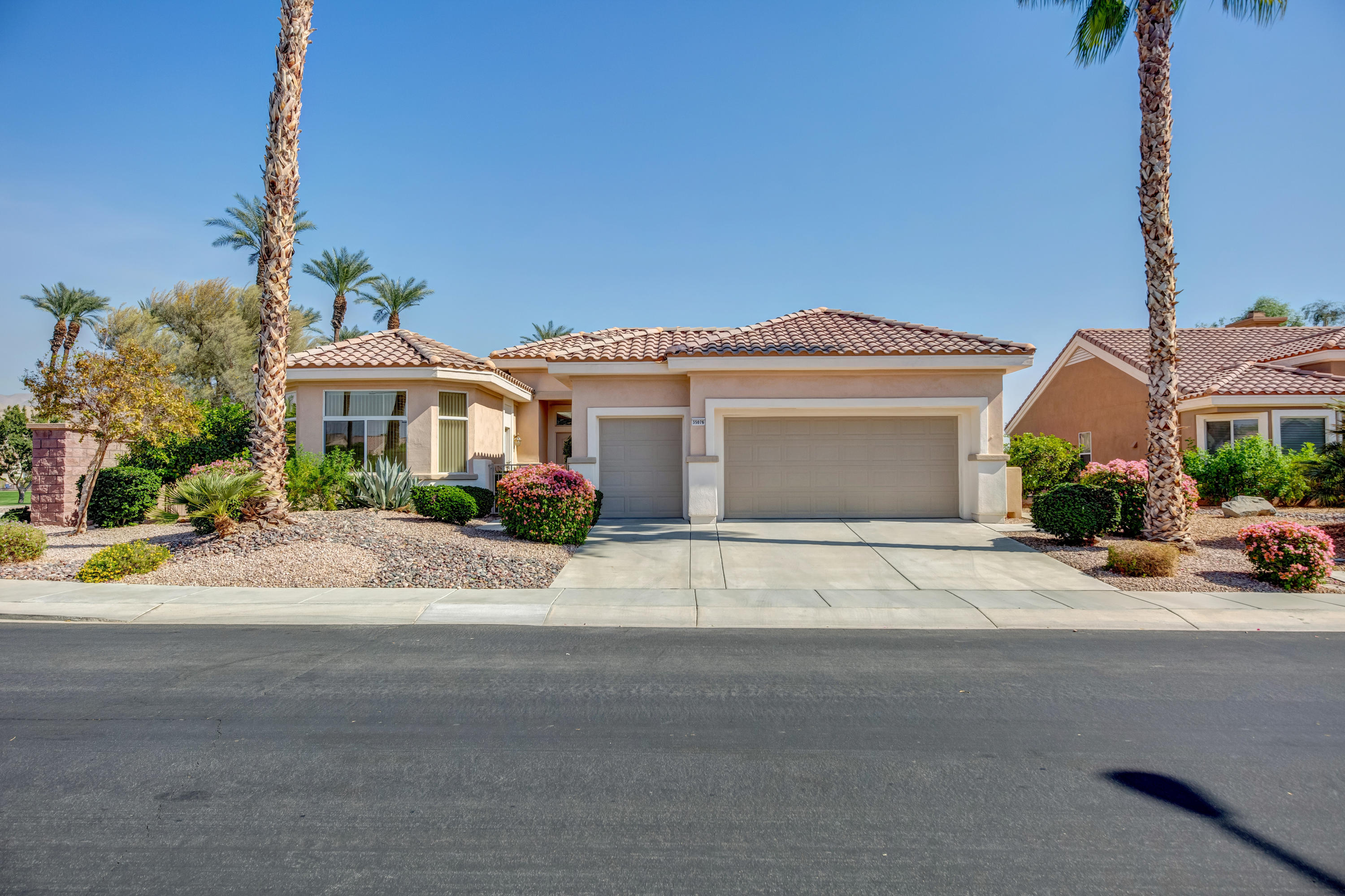 35076 Moorbrook Road Palm Desert, CA 92211 - Photo 5 of 45 a front view of a house with a yard and potted plants