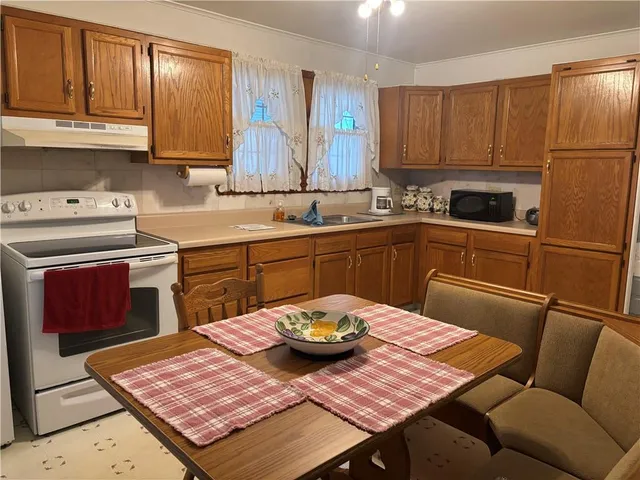 a kitchen with a sink a stove a table and chairs