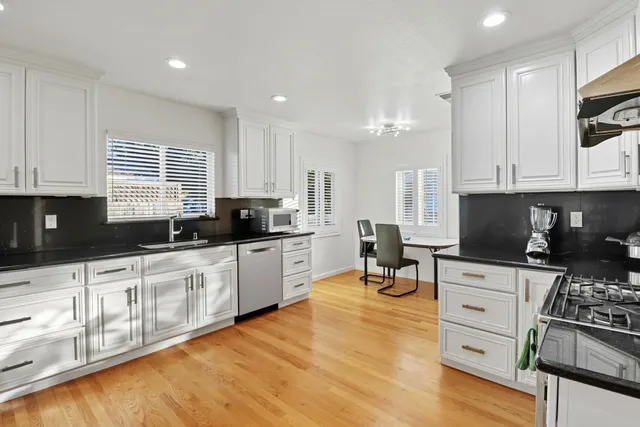 a kitchen with stainless steel appliances kitchen island granite countertop a stove a sink and a microwave