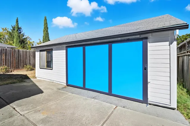 a view of a house with a yard and potted plants