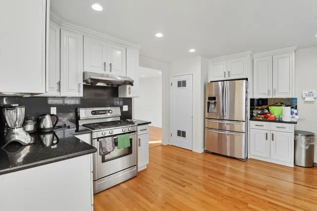 a kitchen with stainless steel appliances granite countertop a refrigerator and a stove top oven