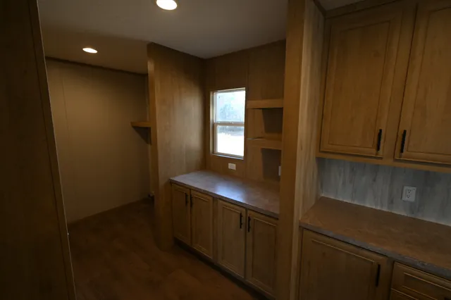 an empty room with wooden floor and entrance