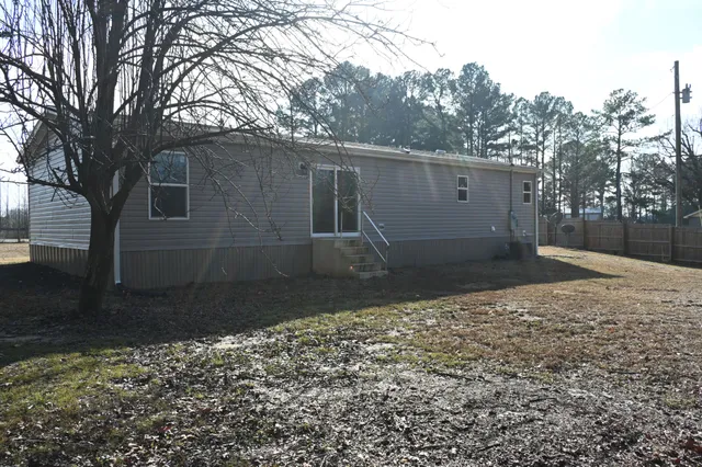 a front view of a house with a yard and trees