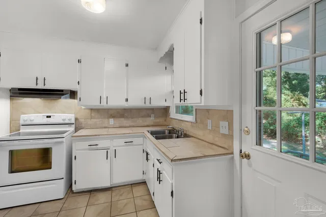 a kitchen with granite countertop white cabinets and white appliances