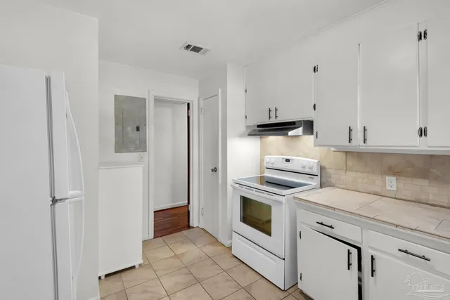 a kitchen with stainless steel appliances white cabinets a window and a sink