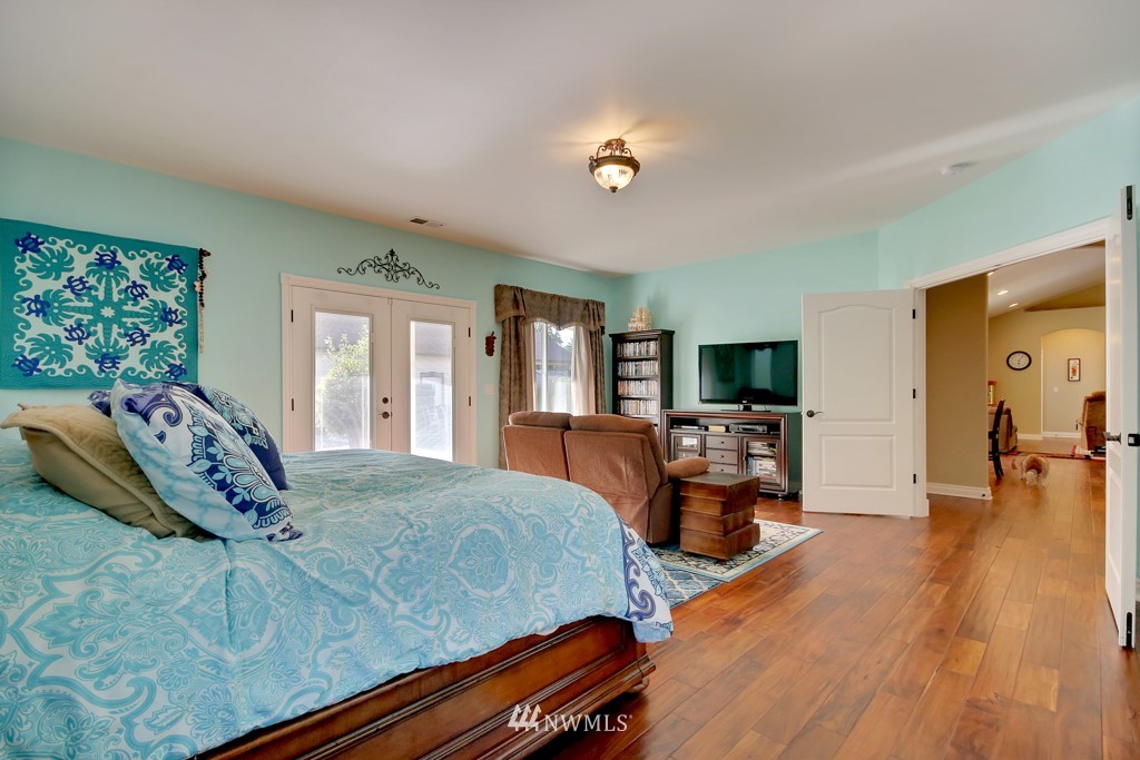 9908 Meadow Road Southwest Lakewood, WA 98499 - Photo 18 of 25 a bedroom with a large bed and a chandelier