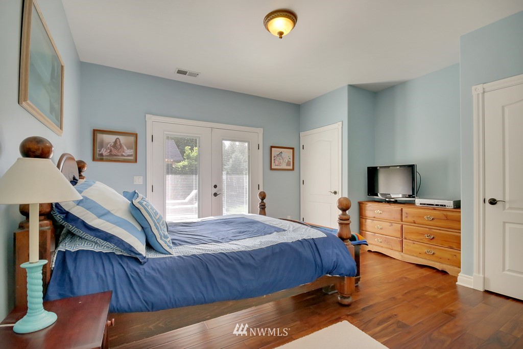9908 Meadow Road Southwest Lakewood, WA 98499 - Photo 9 of 25 a bedroom with a bed and wooden floor