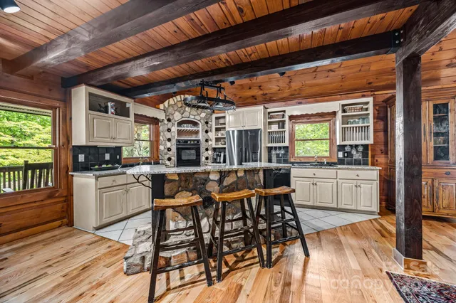 a kitchen with sink a stove and chairs