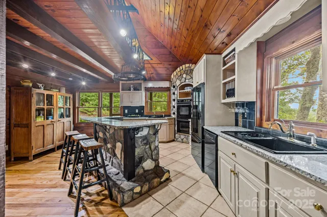 a kitchen with stainless steel appliances granite countertop a table chairs and a wooden floor