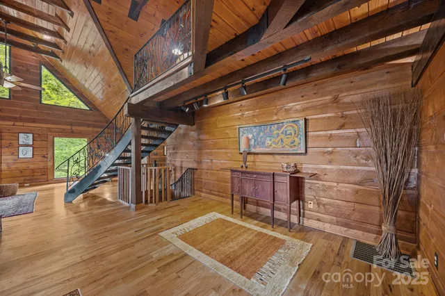 a view of a hallway with wooden floor and stairs