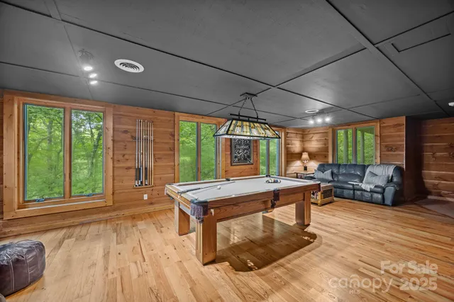 a room with furniture pool table and windows