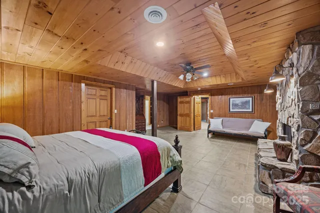 a spacious bedroom with a bed and wooden floor