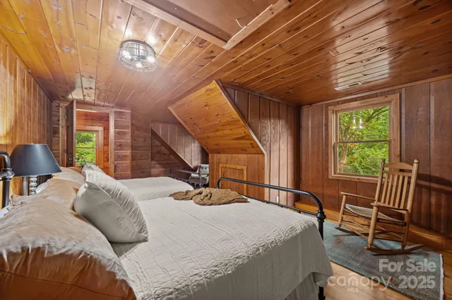 a bedroom with a bed a chandelier and a window