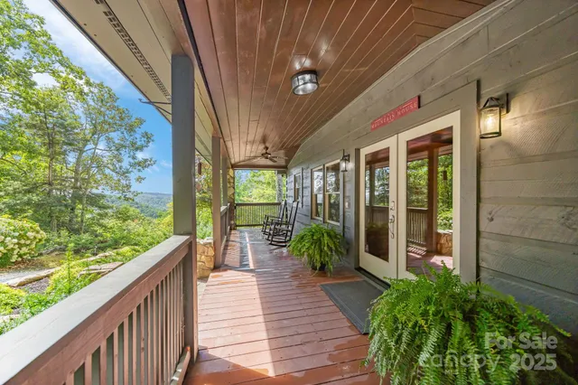 a porch with chairs next to a yard