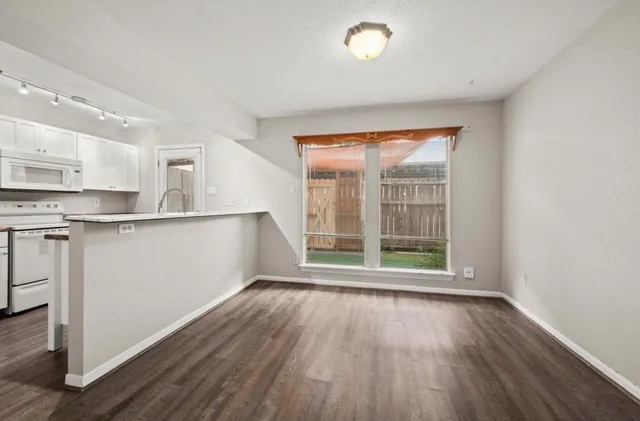 a view of a kitchen with wooden floor and electronic appliances