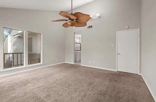 a view of an empty room with a chandelier fan