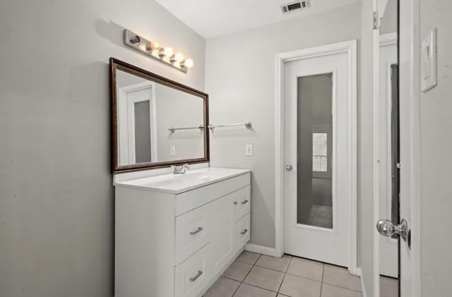 a bathroom with a granite countertop sink and a mirror